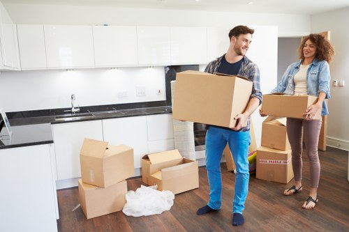 Professional movers carrying household items through a Hackney Wick apartment building